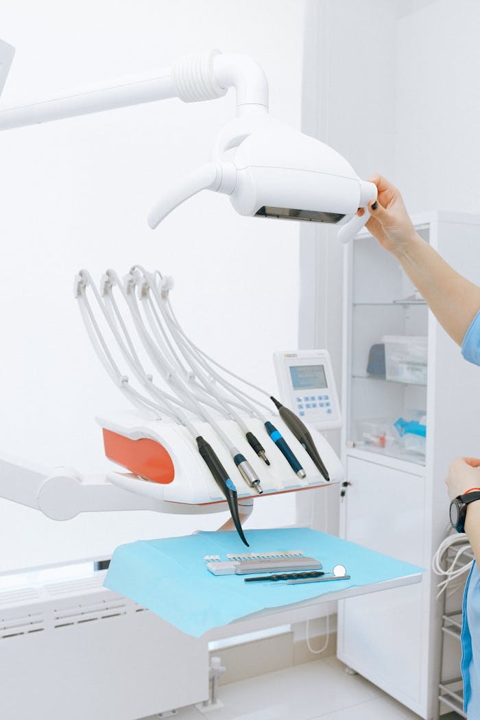 Contemporary white medical dental instruments with lamp placed on white desk in modern light office in clinic