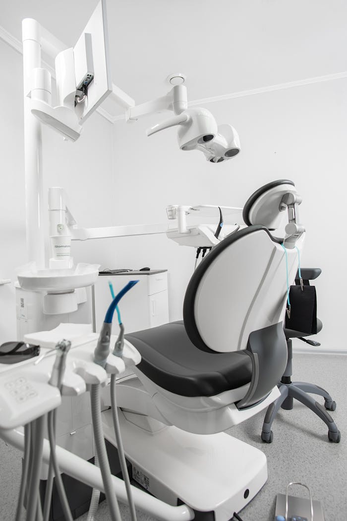 Bright and sterile dental clinic room featuring modern equipment and a dental chair.